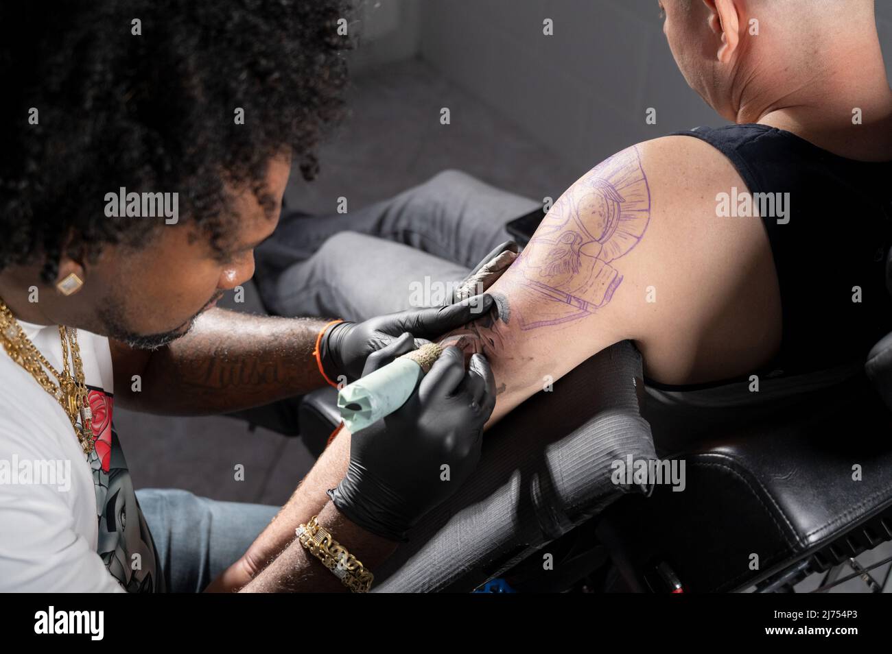 L'artiste professionnel américain de tatouage d'Afrique fait un tatouage sur le bras de client. Photographie de haute qualité. Banque D'Images