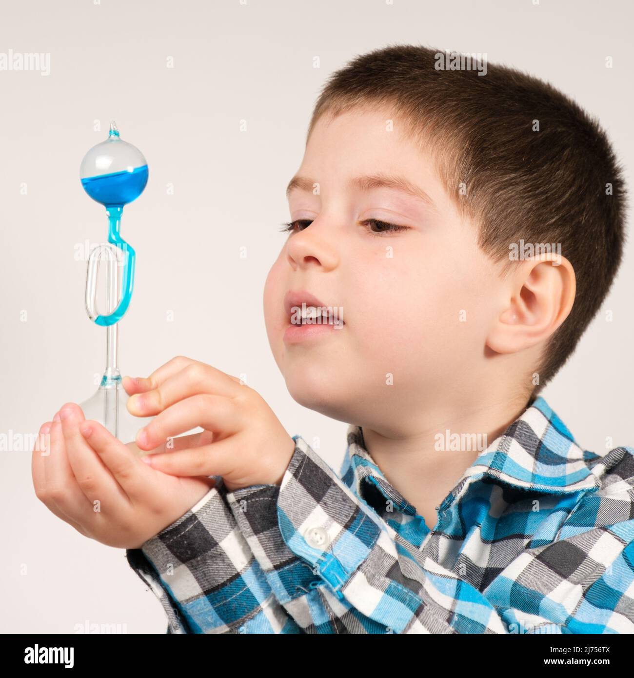 Un garçon de 4 ans étudie la chimie, tenant dans sa main une fiole avec un  liquide bleu qui remonte de la chaleur corporelle Photo Stock - Alamy