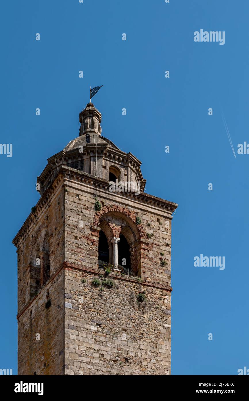 Le clocher de l'ancienne Pieve di San Giovanni Battista, Buti, Pise, Italie, avec un avion laissant son sentier en arrière-plan Banque D'Images