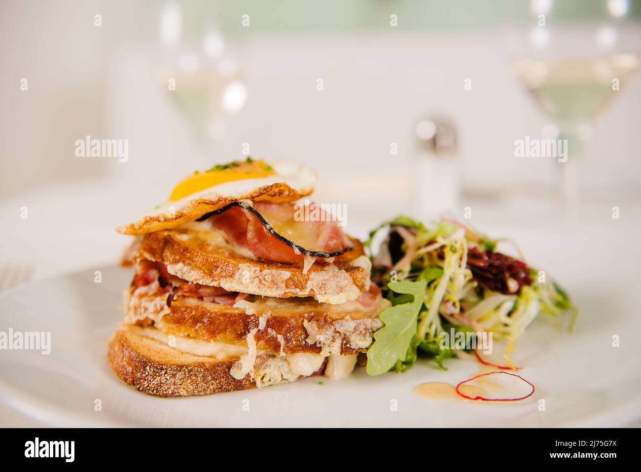 Croque Madame (toast recouvert de jambon sec, fromage grillé et œuf frit) Banque D'Images