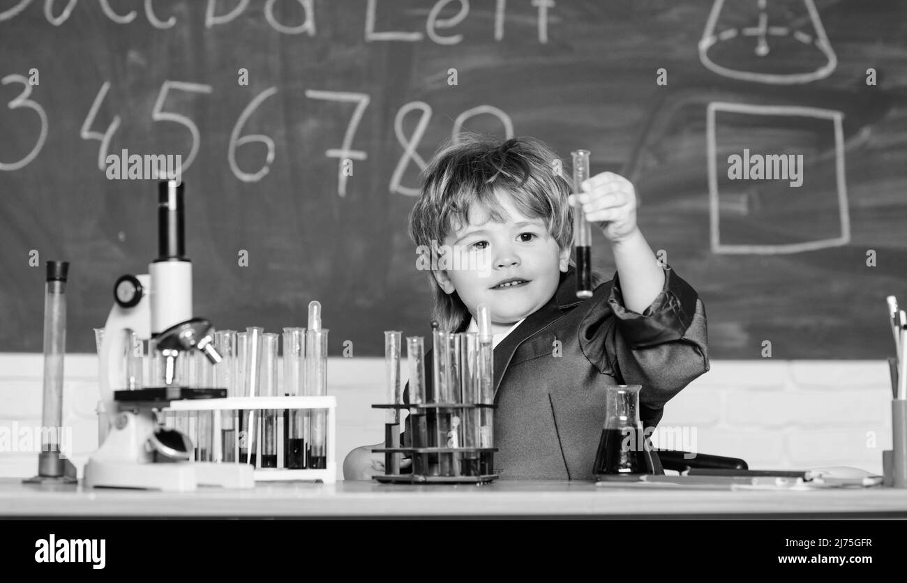 tubes à essai avec liquide pour la recherche. petit garçon étude chimie. résultat. Concept médical. Petit enfant. Petit garçon utilisant le microscope à la leçon d'école Banque D'Images