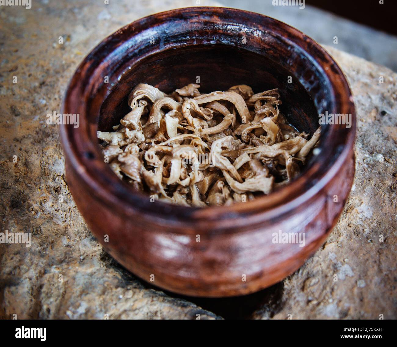 Champignons de Bhuanais cuisant dans une casserole en bois Banque D'Images