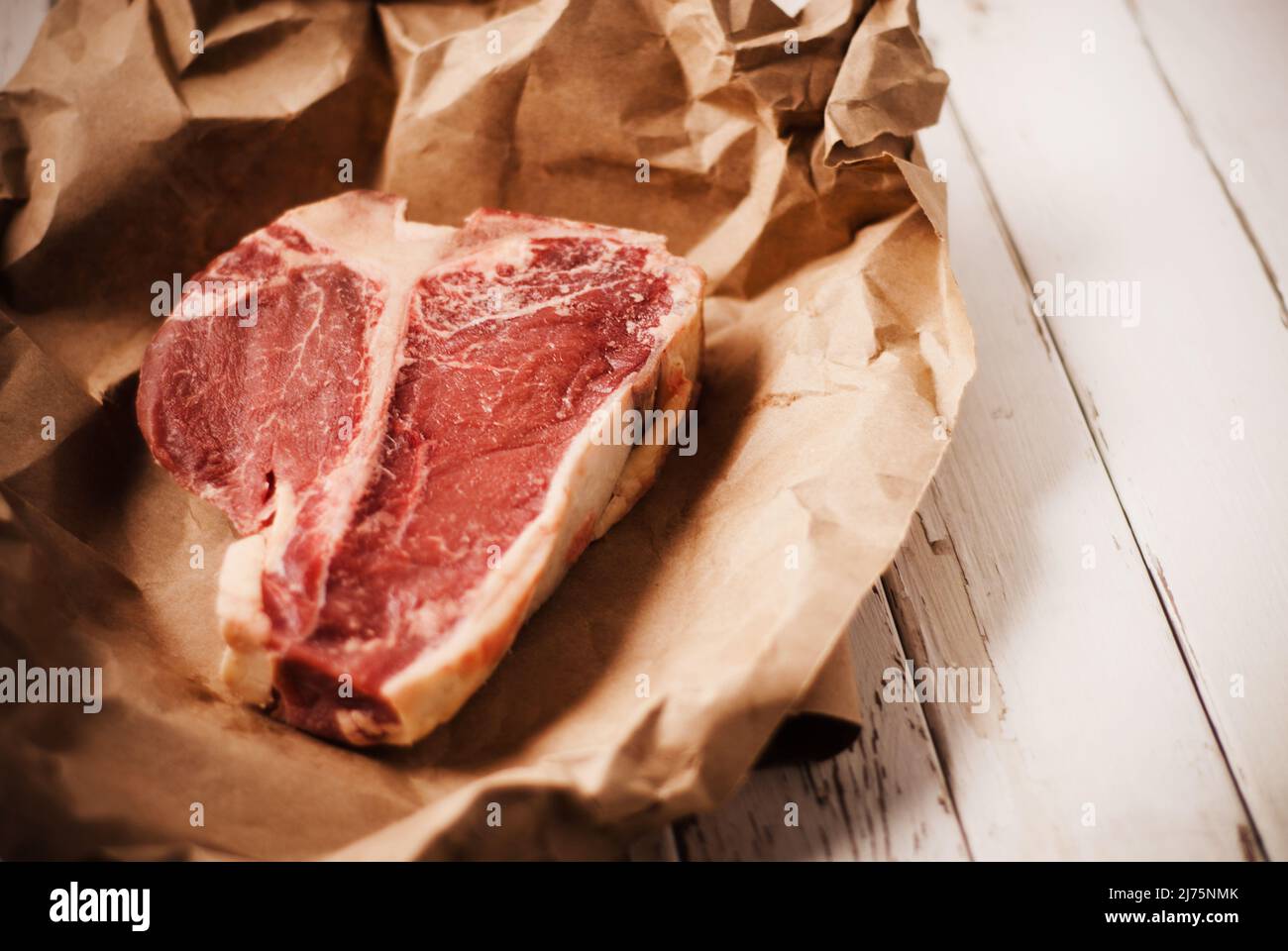 Steak d'os en T brut sur papier Banque D'Images