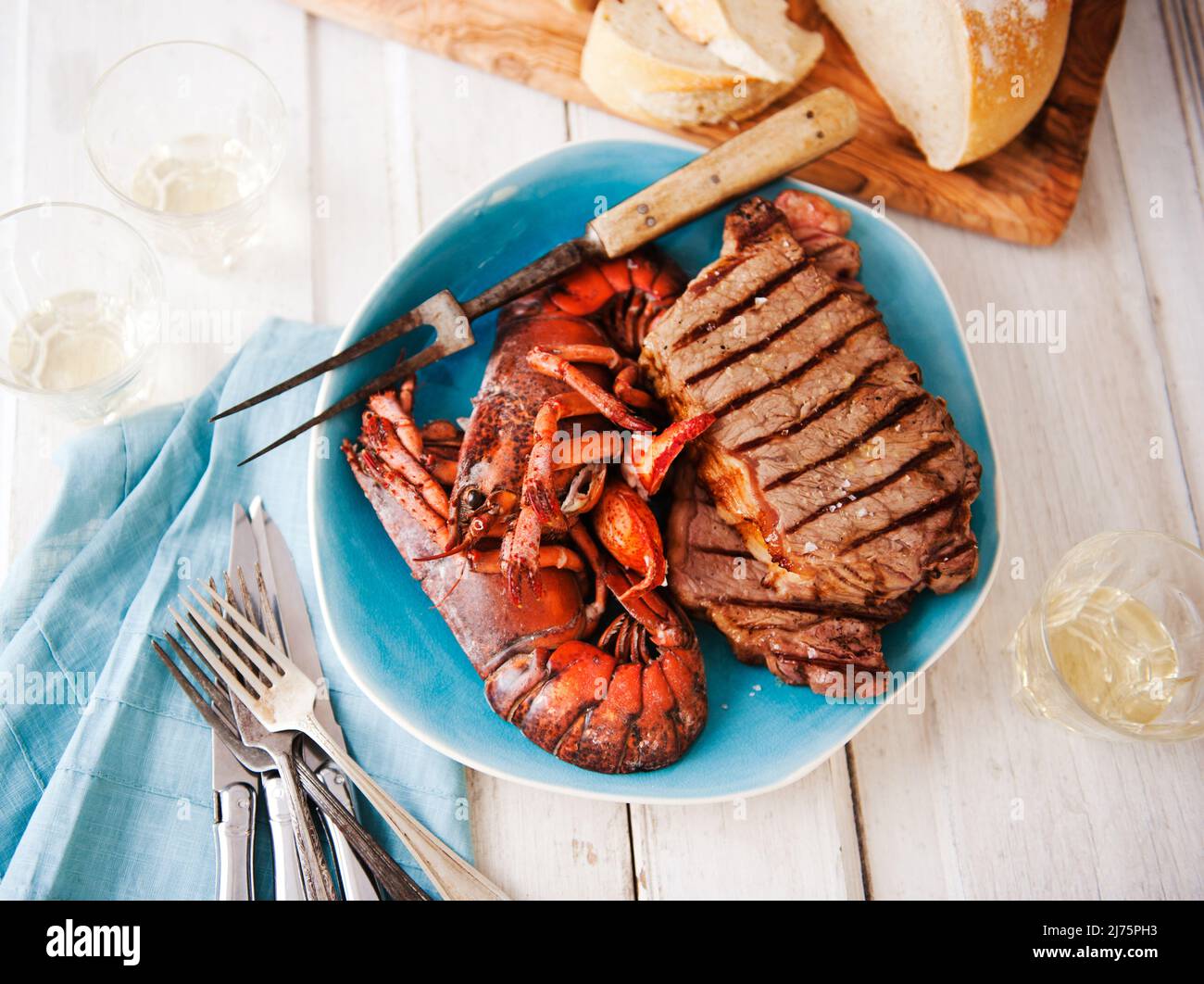 Plateau de surf et de gazon avec homard et steak; pain à l'arrière-plan Banque D'Images