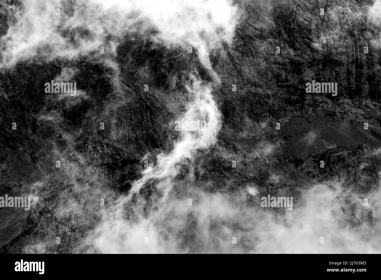 Des nuages sur le Lalidererwänden dans le Risstal, près d'Engalm, Tyrol / Autriche, dans le parc naturel de Karwendel en automne, par temps variable. Par le contre-jour du soleil, brille le brouillard et les nuages devant les rochers noirs. Banque D'Images