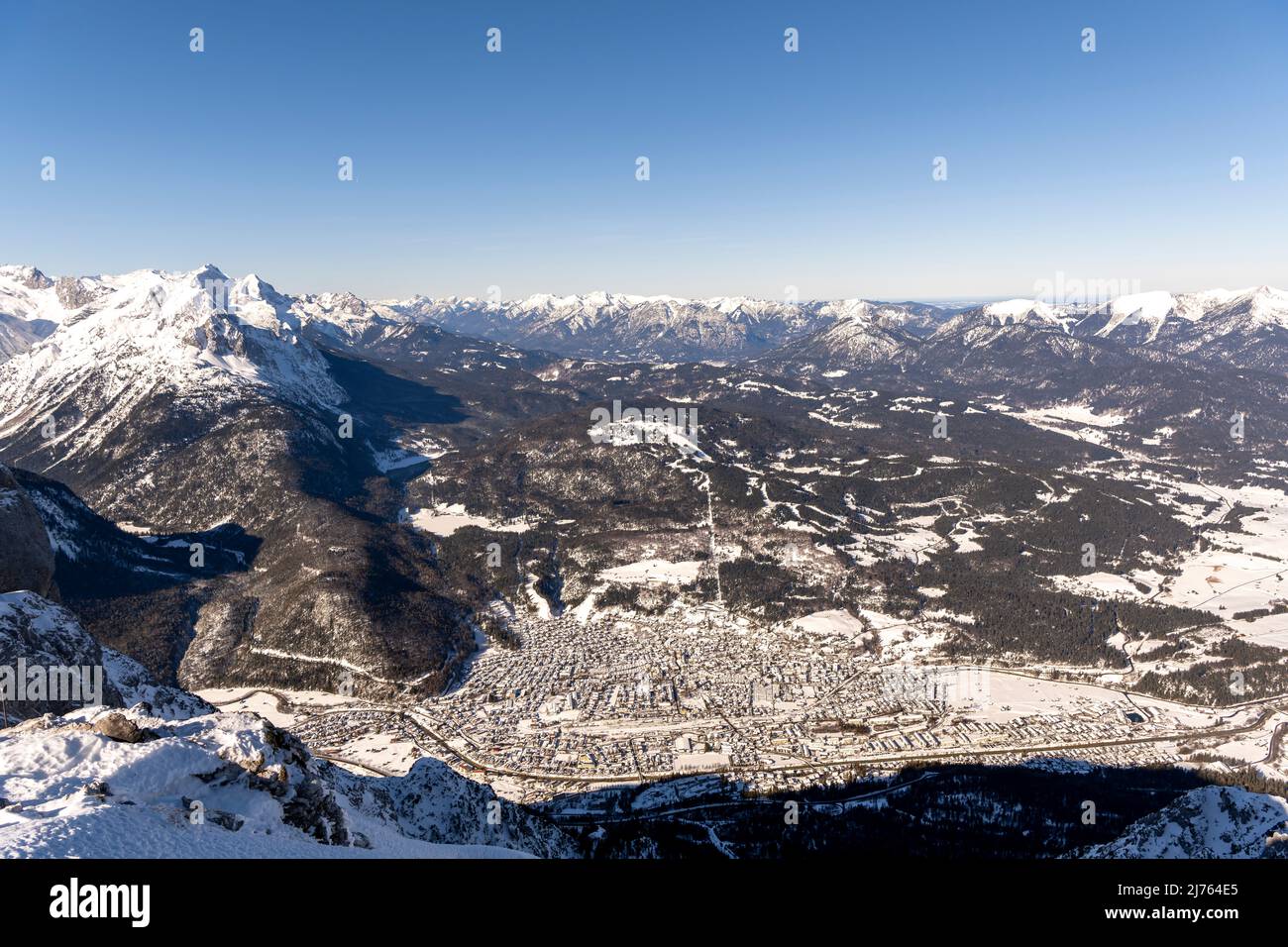 La ville de marché Mittenwald en hiver prise de l'ouest du Karwendel, la station de montagne du Karwendelbahn. Outre la neige, la glace et le village idyllique, vous pouvez bien voir le Kranzberg, les montagnes de Wetterstein et en arrière-plan les contreforts bavarois des Alpes, Jusqu'au Zugspitze avec ciel bleu et air clair. Banque D'Images
