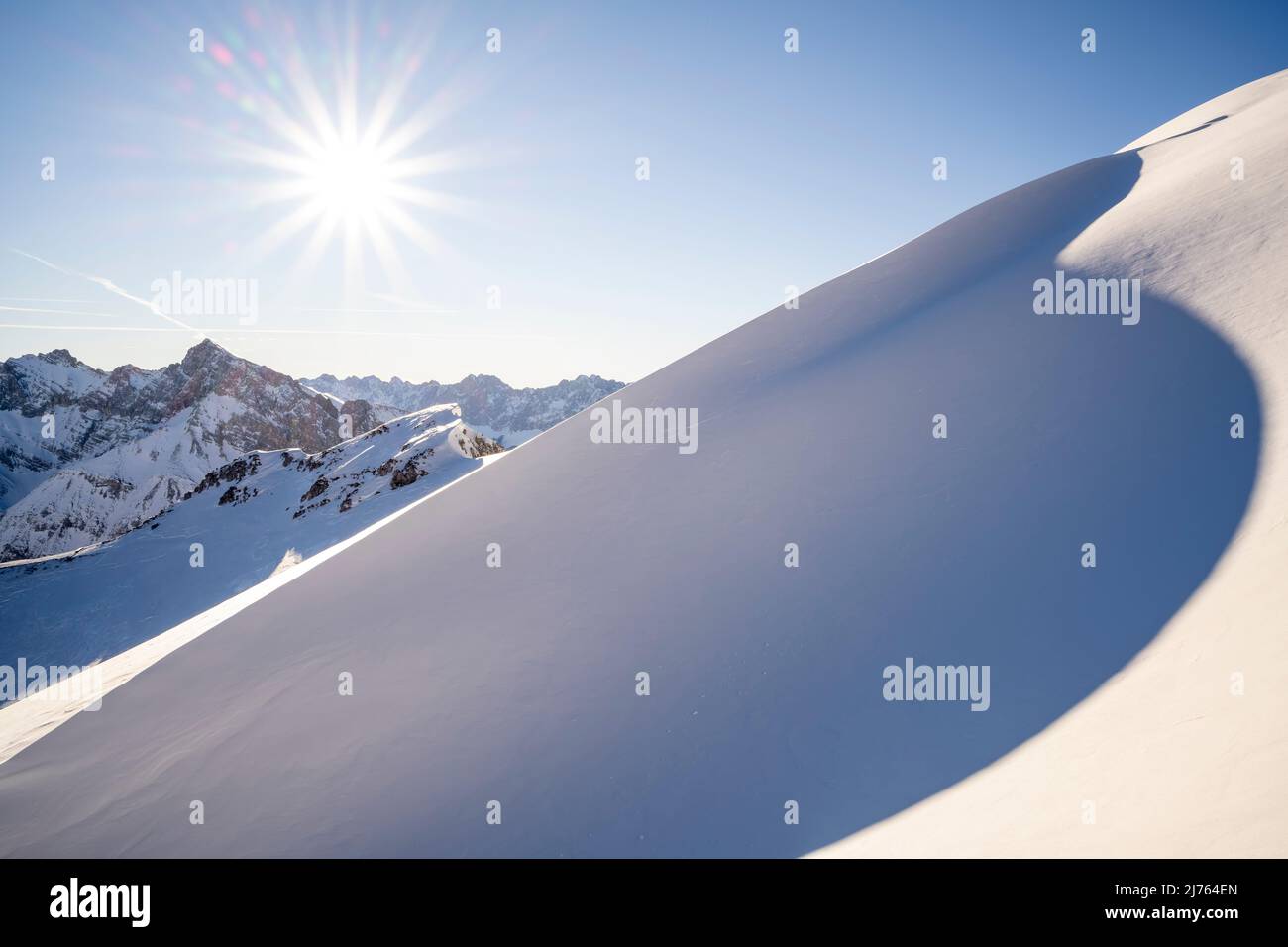 Soleil d'hiver sur le Pléisenspitze et le Karwendel, au premier plan une dérive de neige, sous forme d'une dune avec ombre dans le creux. Banque D'Images