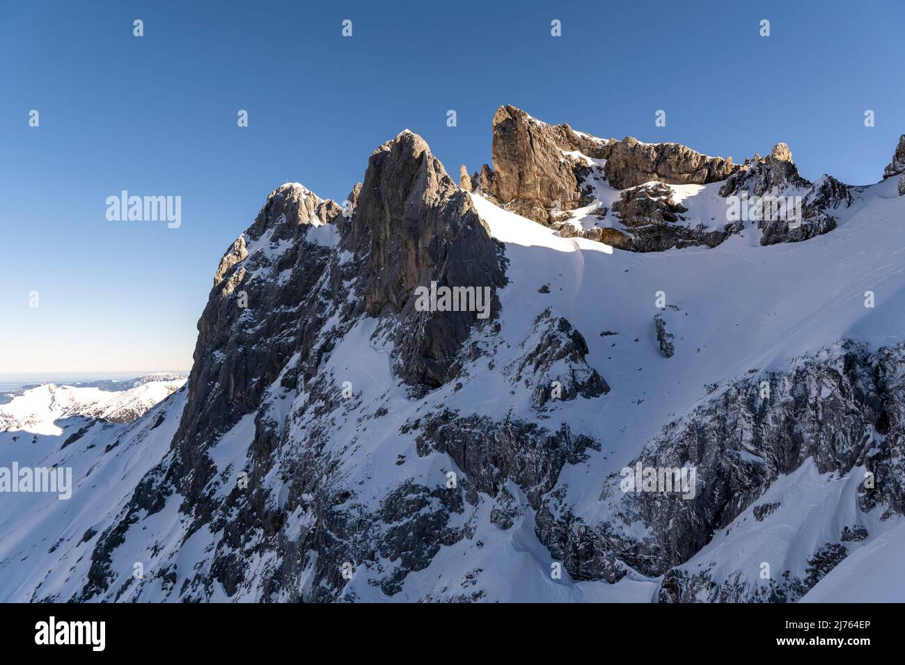 Les montagnes Karwendelköpfe au-dessus de la station de montagne Mittenwald Karwendel en hiver avec de la neige. Les rochers enneigés s'élèvent dans le ciel bleu. Banque D'Images Les montagnes Karwendelköpfe au-dessus de la station de montagne Mittenwald Karwendel en hiver avec de la neige. Les rochers enneigés s'élèvent dans le ciel bleu. Banque D'Images