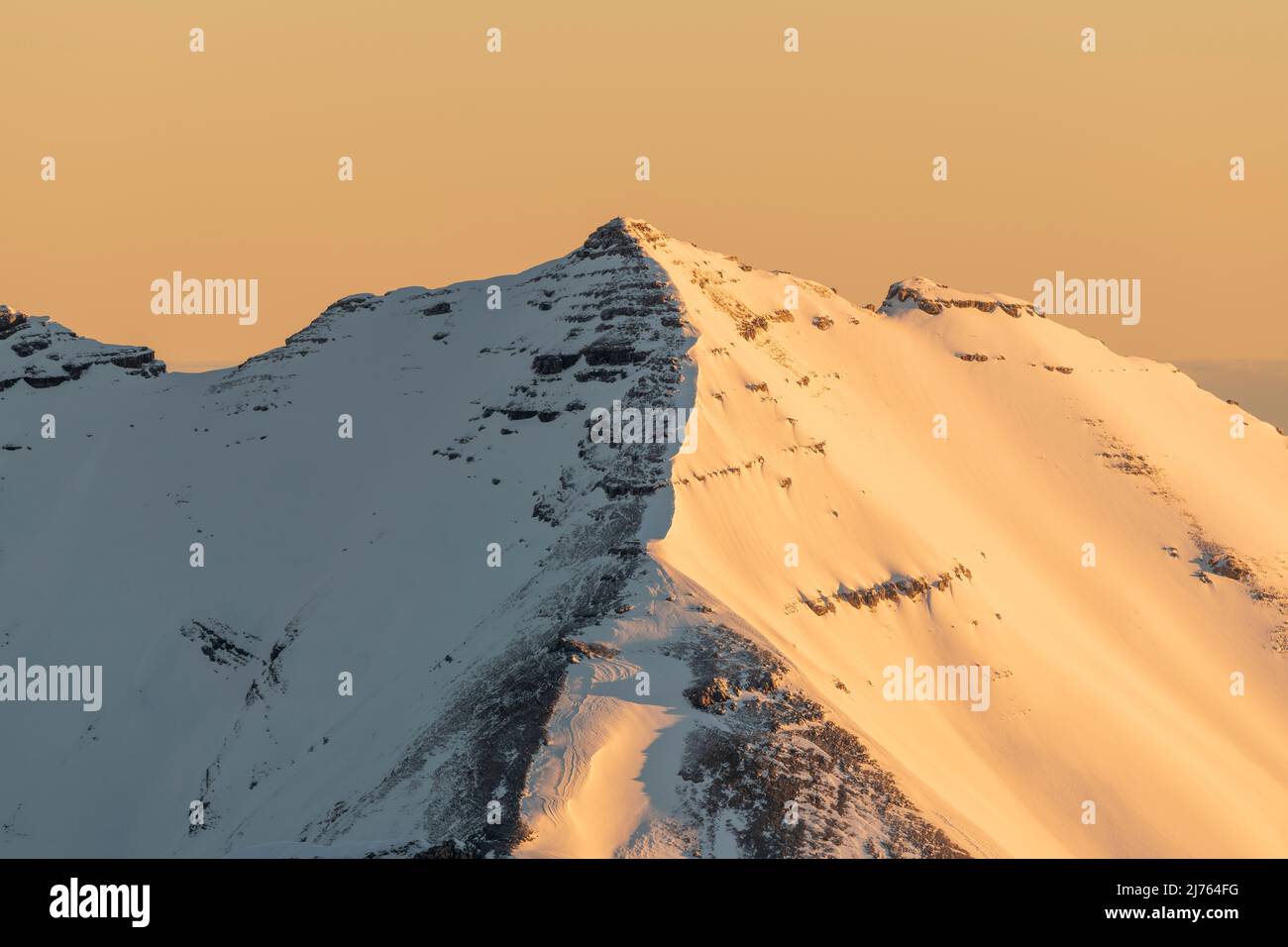 Le Soiernspitze brille dans une lumière dorée orange au lever du soleil. Pris en hiver avec la neige et la glace de l'ouest du Karwendelspitze au-dessus de Mittenwald. Banque D'Images