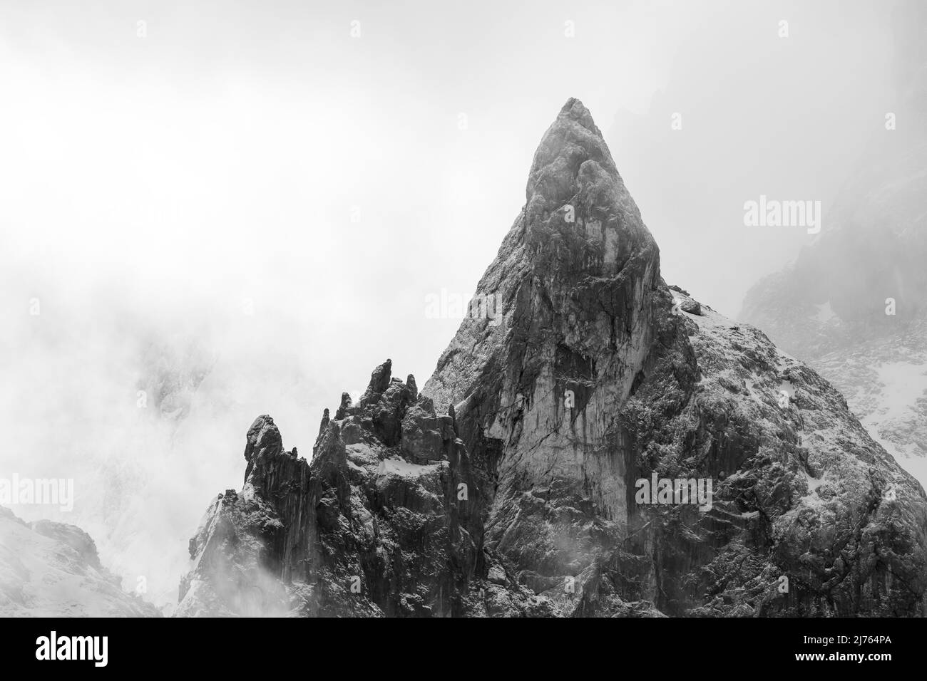 Un pic rocailleux très frappant, plutôt dentelé, en hiver dans la neige et WOlken ou atmosphère de brouillard dans le Karwendel en dessous de l'est Karwendelspitze et au-dessus de ce que l'on appelle Torscharte, au cours d'une courte période le temps a changé massivement et ainsi toujours offert de nouvelles impressions de ce rocher frappant. Banque D'Images