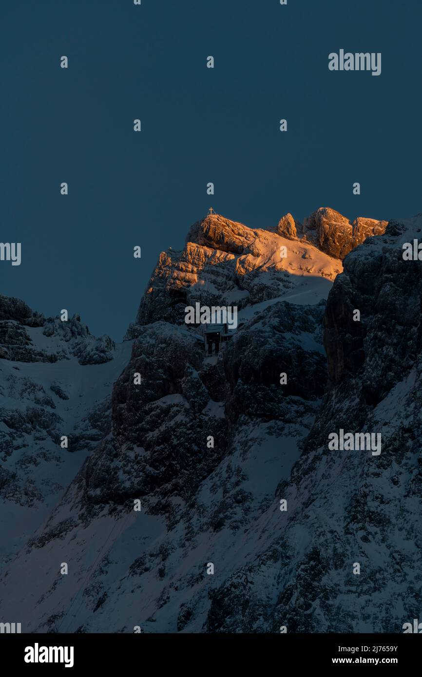 Pic du Karwendelspitze occidental dans la lumière du dernier soir, sous la station de montagne du Karwendelbahn à l'ombre. Photo prise en hiver avec de la neige et de la glace. Banque D'Images Pic du Karwendelspitze occidental dans la lumière du dernier soir, sous la station de montagne du Karwendelbahn à l'ombre. Photo prise en hiver avec de la neige et de la glace. Banque D'Images