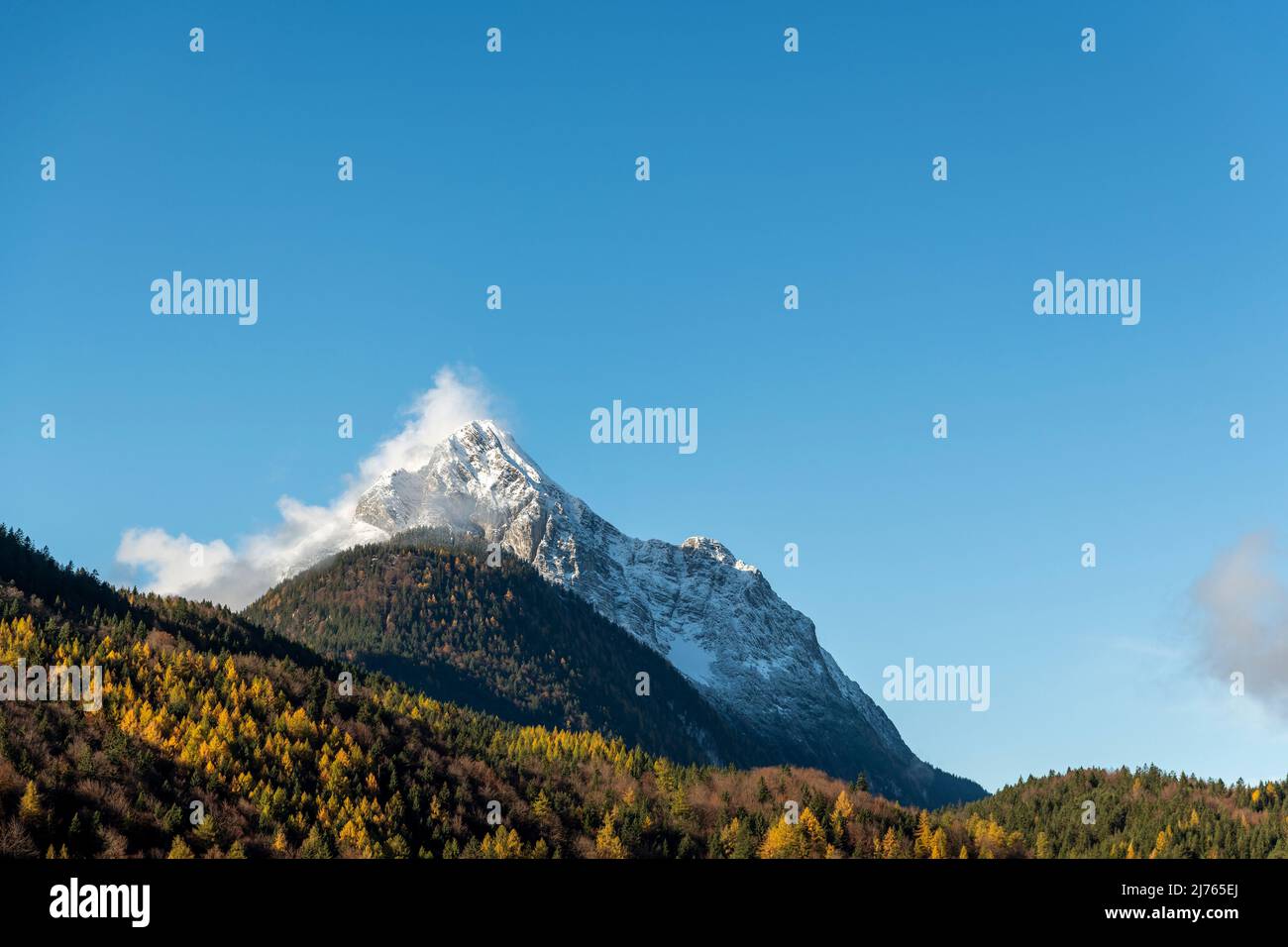 Le Wetterstein, partie de la chaîne de montagne du même nom entre Garmisch-Partenkirchen et Mittenwald, vu du village en feuilles d'automne et ciel bleu, avec de la neige sur la montagne. Banque D'Images Le Wetterstein, partie de la chaîne de montagne du même nom entre Garmisch-Partenkirchen et Mittenwald, vu du village en feuilles d'automne et ciel bleu, avec de la neige sur la montagne. Banque D'Images