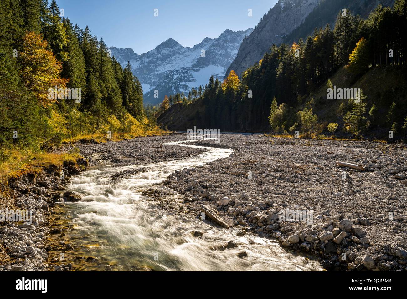 Automne à Johannisbach à Johannistal près de Hinterriss à Karwendel, Tyrol / Autriche. Le ruisseau de montagne serpente à travers son lit de gravier naturel, en arrière-plan les murs de Laliderer avec la première neige. Banque D'Images