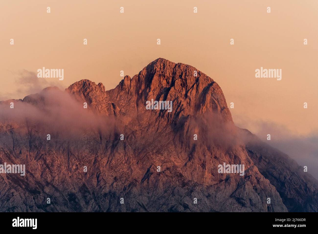 Le pic du Karwendel oriental brille de rouge au coucher du soleil, un léger voile de nuages peut être vu. Prise de la banque dite Fleischbank. Banque D'Images