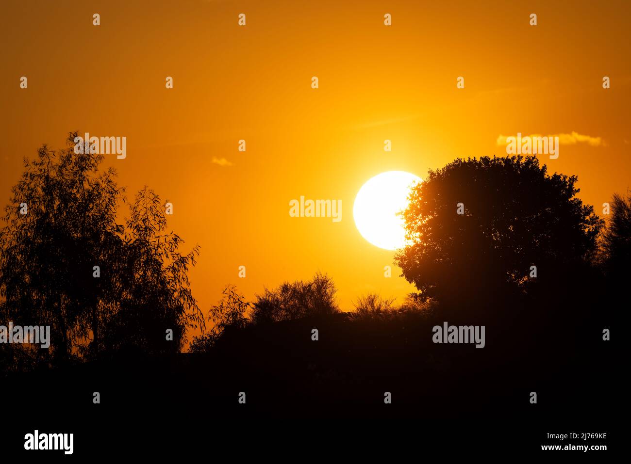 Soleil sur le point de se cacher au coucher du soleil. Banque D'Images