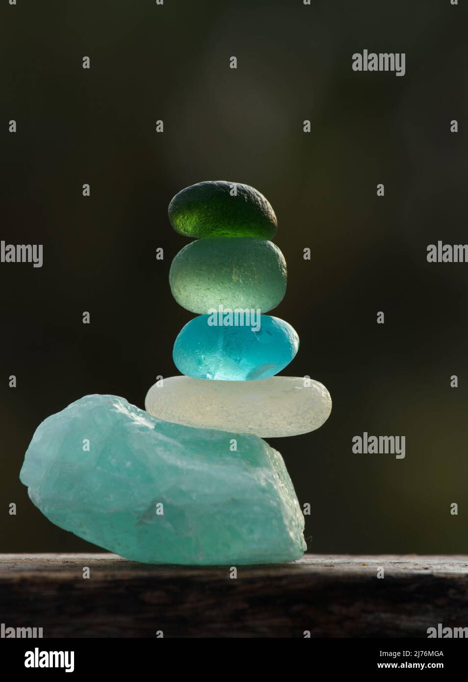 Une vue rapprochée de galets de verre de mer de différentes couleurs se balance sur une pierre apatite rugueuse Banque D'Images Une vue rapprochée de galets de verre de mer de différentes couleurs se balance sur une pierre apatite rugueuse Banque D'Images