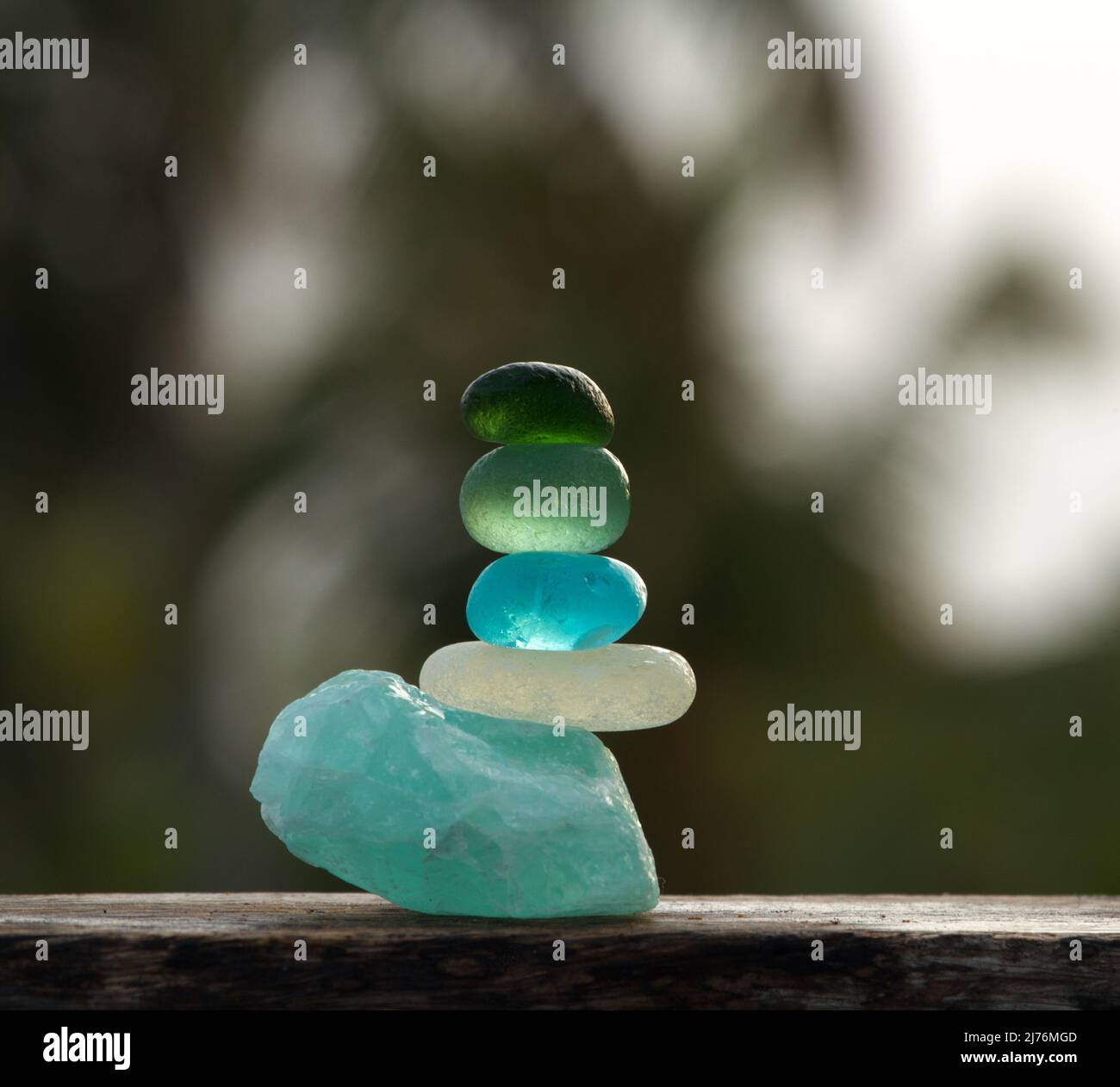 Une vue rapprochée de galets de verre de mer de différentes couleurs se balance sur une pierre apatite rugueuse Banque D'Images Une vue rapprochée de galets de verre de mer de différentes couleurs se balance sur une pierre apatite rugueuse Banque D'Images