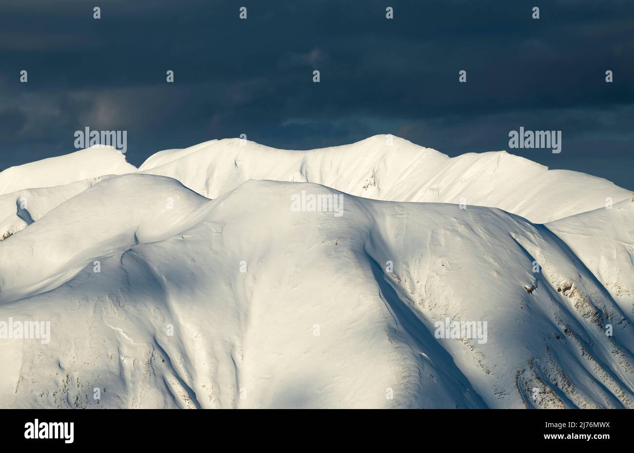 Des montagnes enneigées d'hiver ensoleillées près d'Oberstdorf en face de nuages sombres. Allgäu Alpes, Bavière, Allemagne Banque D'Images