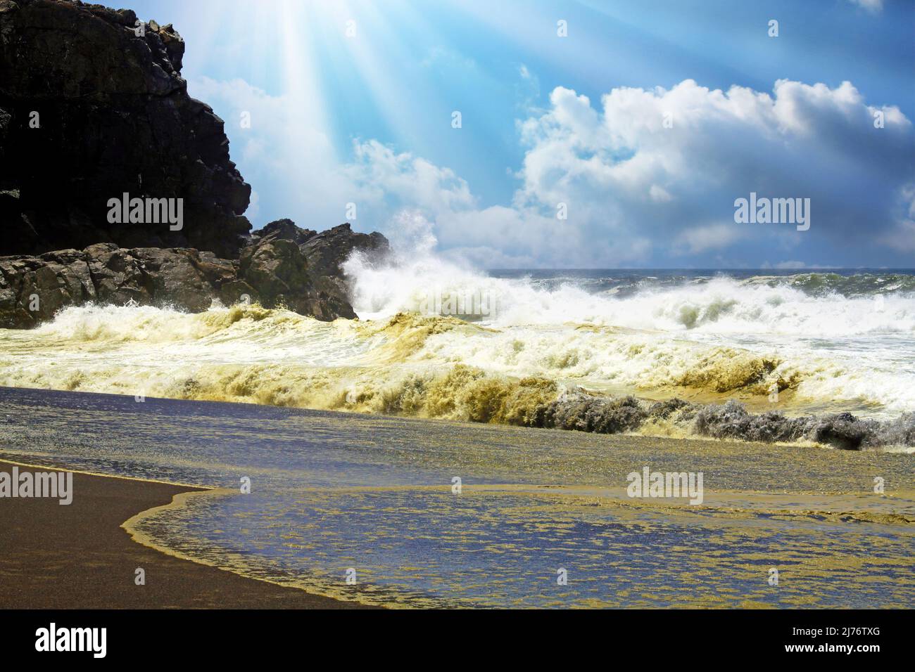 Vagues de surf violentes et lourdes se brisant sur une plage de sable de lave noir isolée et des rochers, pulvérisation de mer et mousse, rayons du soleil nuages de contre-jour - Cobquecura, Chili Banque D'Images