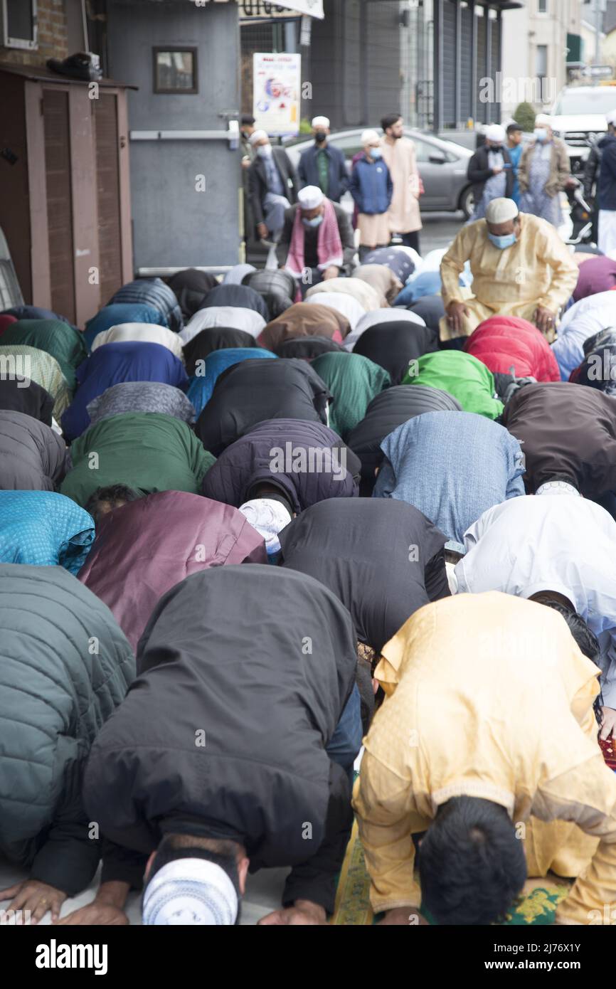 Des hommes musulmans prient sur Eid à l'extérieur d'une mosquée de Brooklyn, NY, dans le quartier de Kensington « Little Bangladesh ». EID al-Fitr 'fête de la rupture du jeûne') est une fête religieuse importante célébrée par les musulmans dans le monde entier qui marque la fin du Ramadan, le mois Saint islamique du jeûne (scim). Banque D'Images