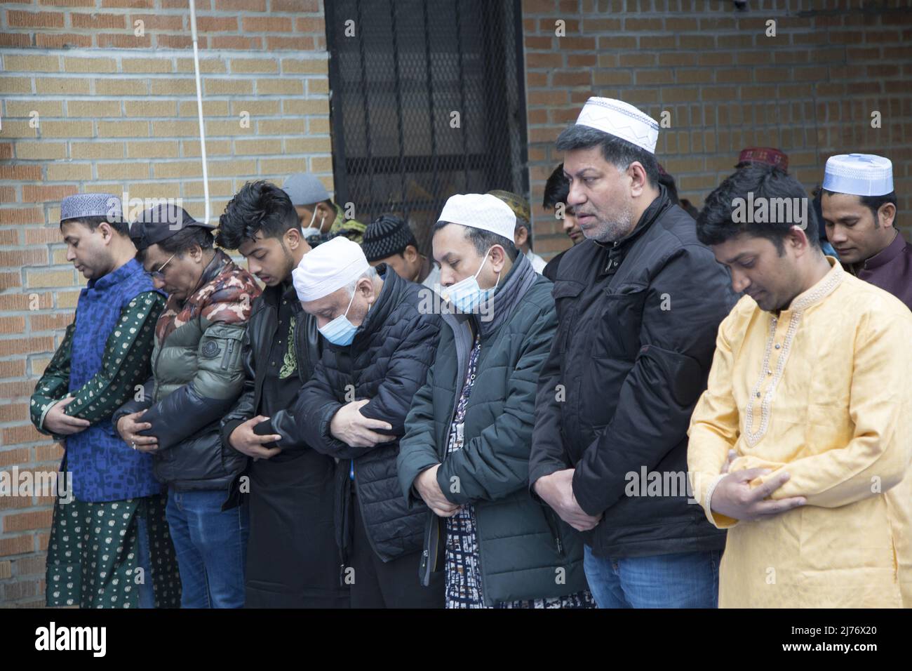 Des hommes musulmans prient sur Eid à l'extérieur d'une mosquée de Brooklyn, NY, dans le quartier de Kensington « Little Bangladesh ». EID al-Fitr 'fête de la rupture du jeûne') est une fête religieuse importante célébrée par les musulmans dans le monde entier qui marque la fin du Ramadan, le mois Saint islamique du jeûne (scim). Banque D'Images