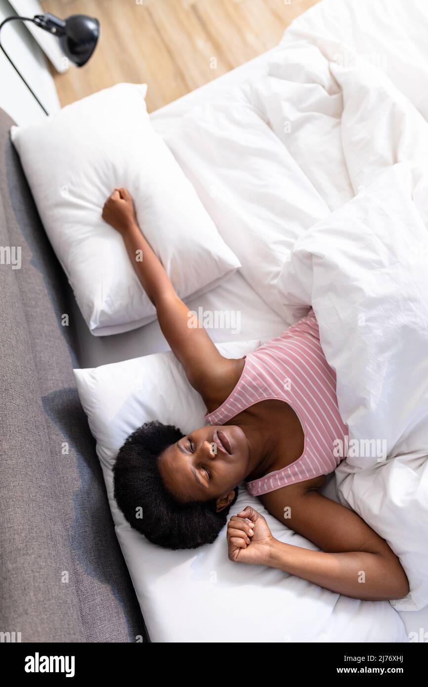 Vue en hauteur d'une femme afro-américaine adulte de taille moyenne qui dormait au lit à la maison Banque D'Images