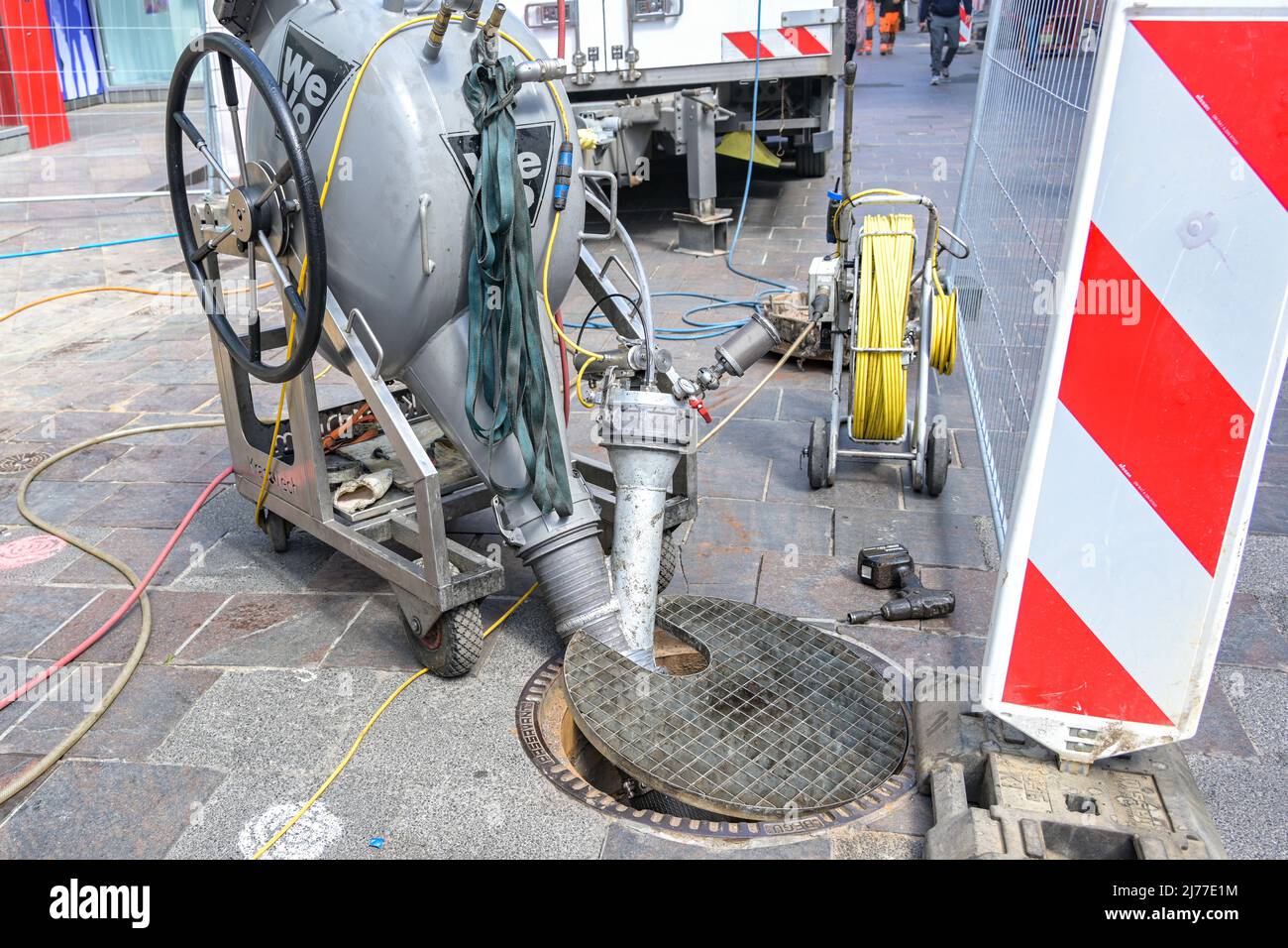 Lubeck, Allemagne, le 4 mai 2022: L'égout travaille avec une machine de pompage et de gros tuyaux à un trou d'homme dans une rue de ville, technologie professionnelle sur une constructio Banque D'Images