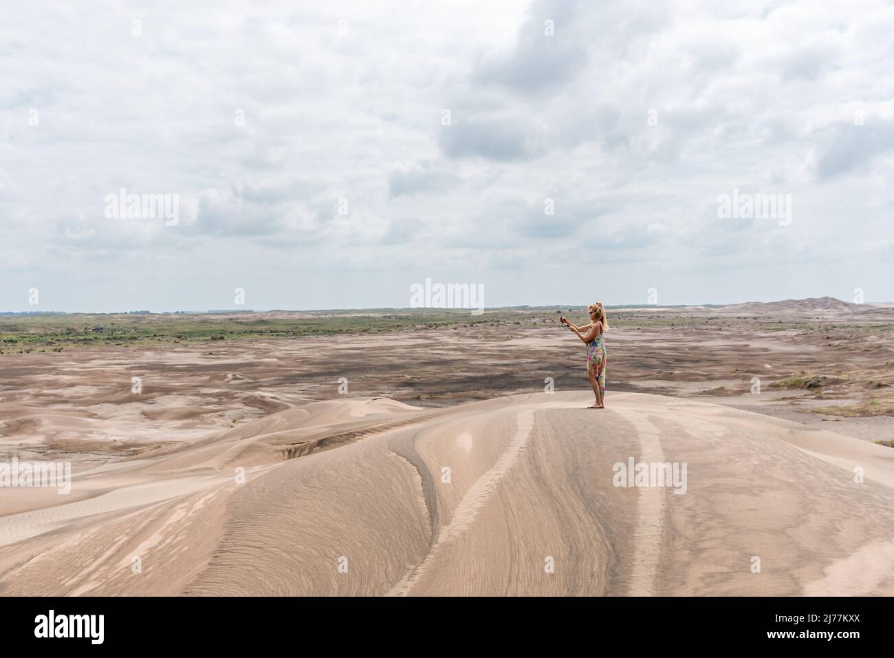 Photo avec espace de copie d'un paysage désertique avec une femme prenant des photos avec son téléphone portable Banque D'Images