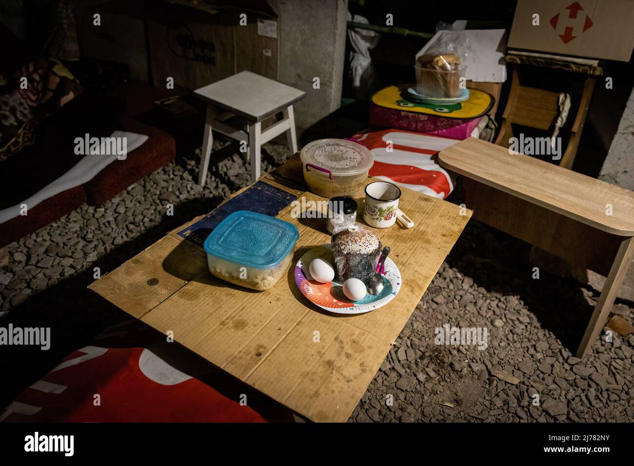 Un cupcake de Pâques et de la nourriture sont vus sur une table dans un bunker souterrain dans le sud-est de Kharkiv. Les citoyens de Kharkiv ont été contraints d’adopter une nouvelle vie souterraine dans des bunkers sans électricité ni eau, la deuxième plus grande ville d’Ukraine étant désormais confrontée à une menace constante de bombardements et de frappes aériennes russes. Banque D'Images