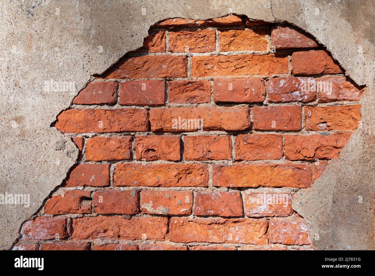 Fragment d'un vieux mur de brique avec le plâtre en fricleur gros plan Banque D'Images