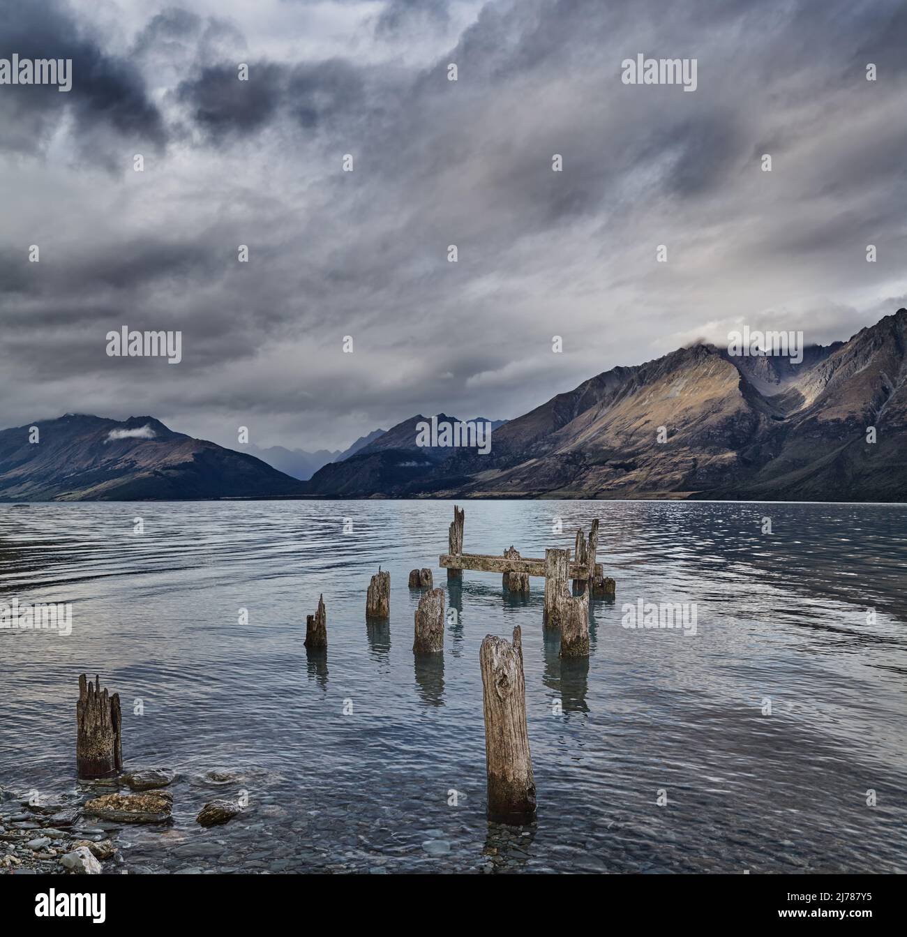 Lac de montagne avec restes de vieux quai en bois à vent nuageux matin Banque D'Images