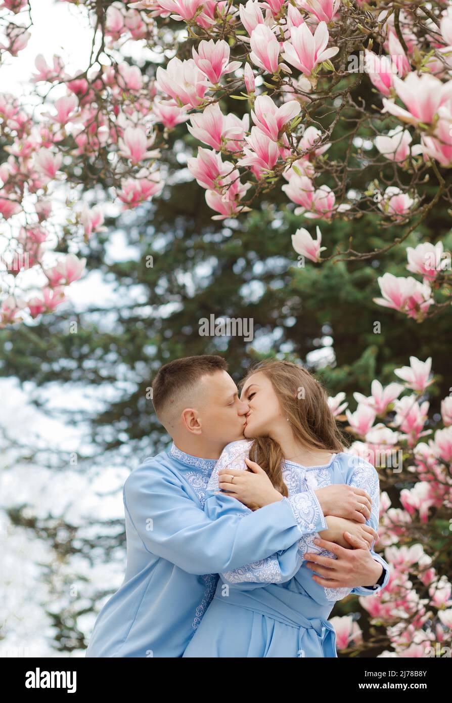 Beau couple embrassant sous le magnolia en fleurs. Villa vintage en arrière-plan Banque D'Images