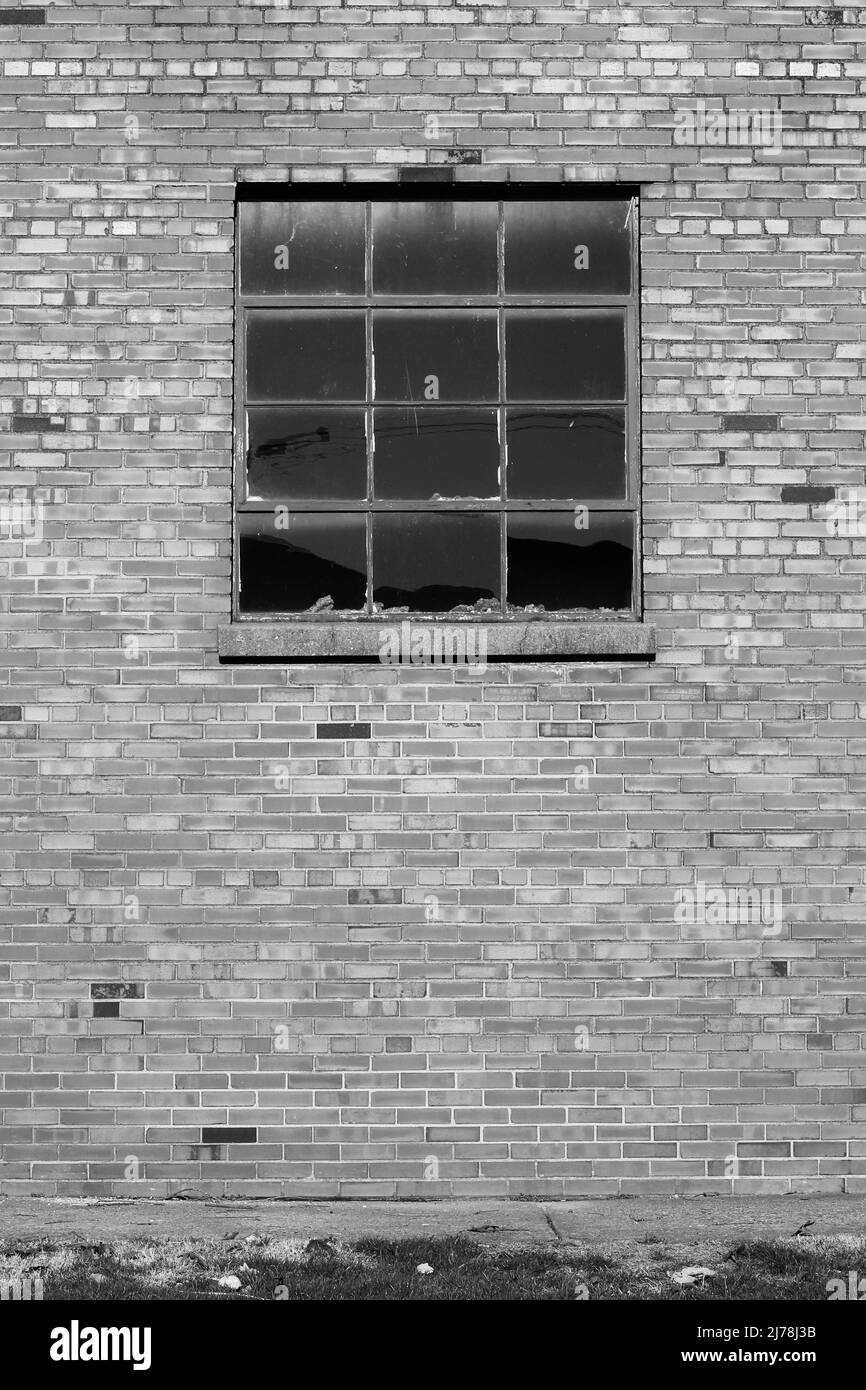 Vintage simple et simple mur de brique d'une usine avec une fenêtre industrielle en noir et blanc. Banque D'Images