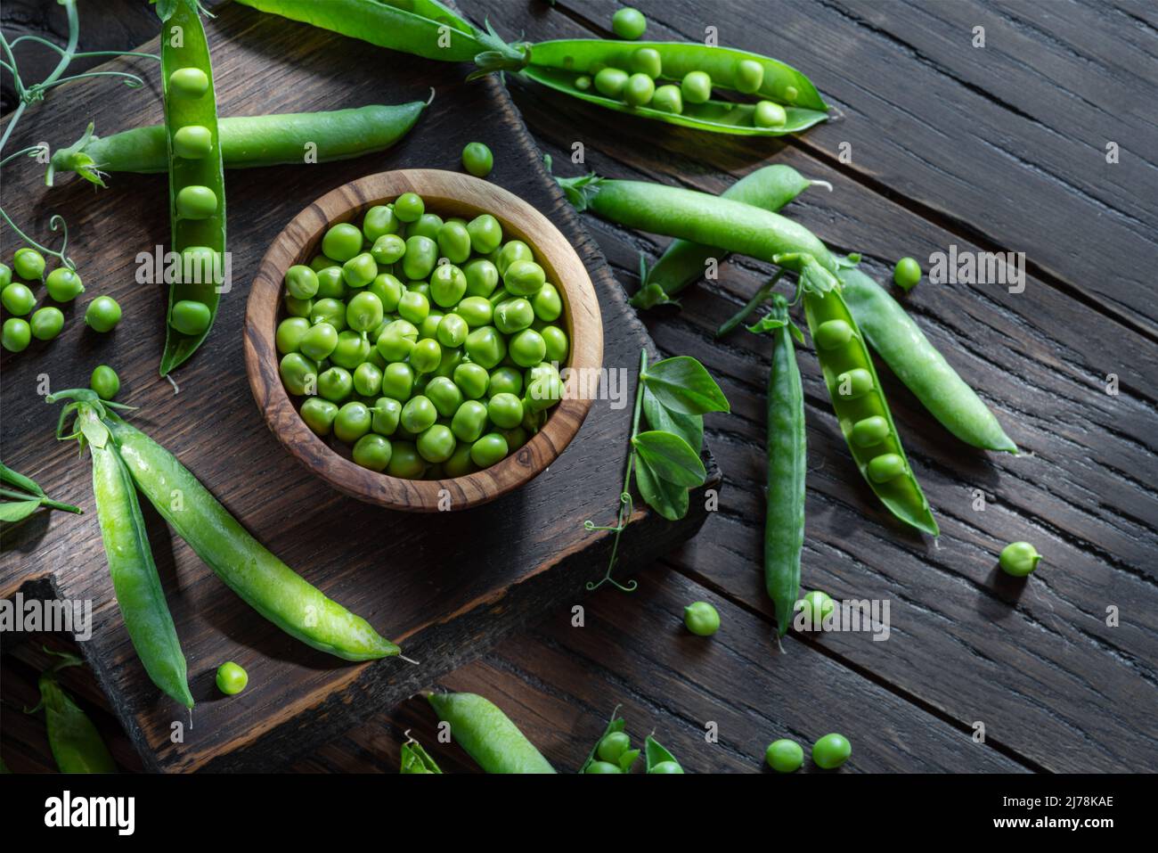 Pois verts et gousses de pois sur une table en bois. Vue de dessus. Banque D'Images