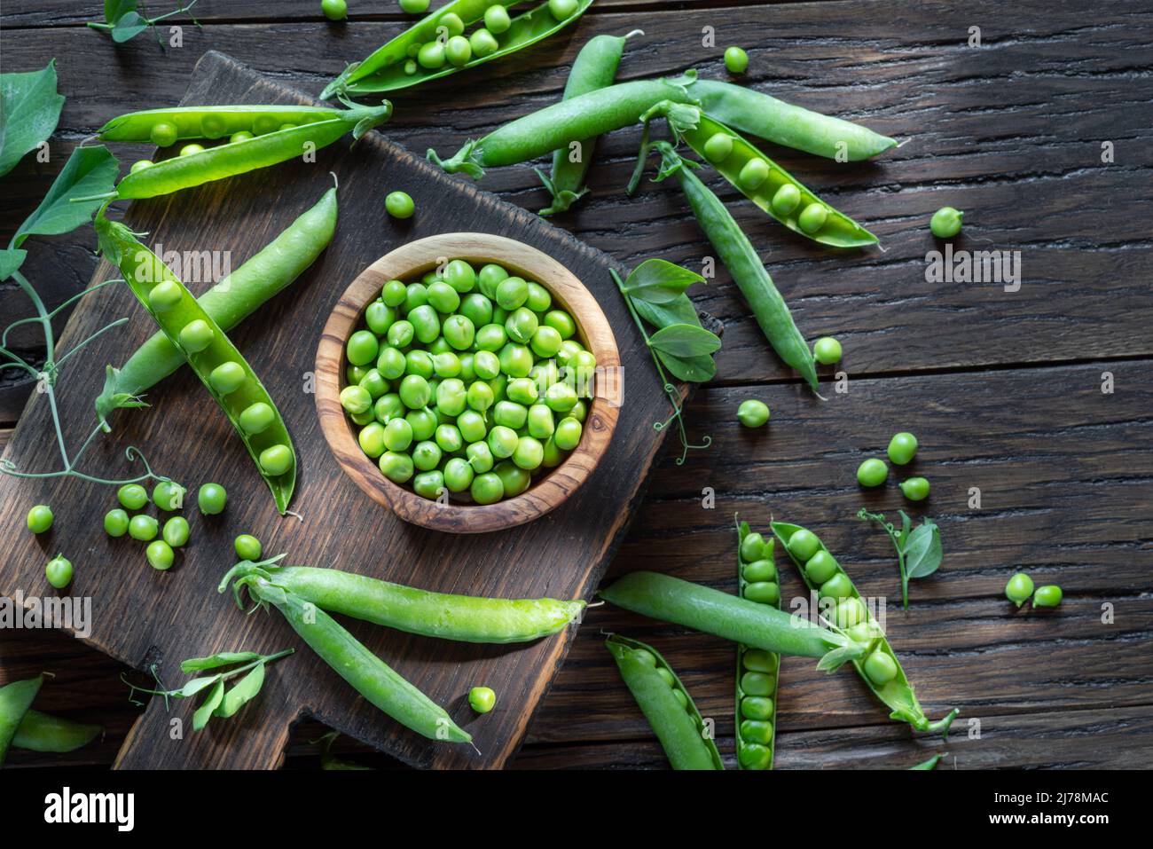 Pois verts et gousses de pois sur une table en bois. Vue de dessus. Banque D'Images