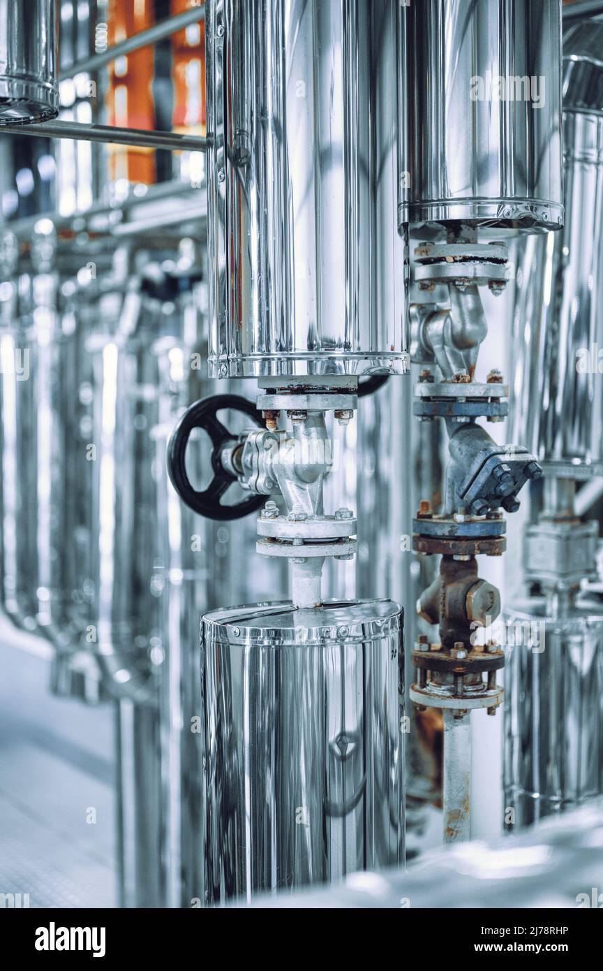 Grand tube avec petite vanne noire à l'usine de production Banque D'Images