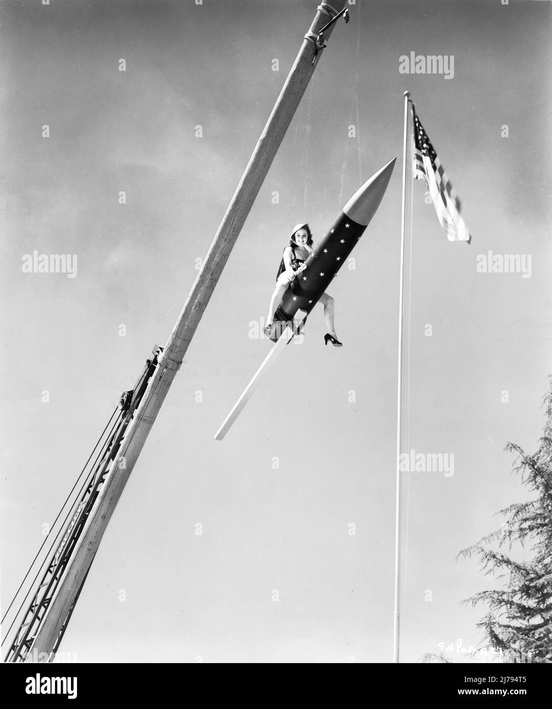 SUSAN HAYWARD 1938 suspendue par une grue assise sur Firework Rocket publicité pour Warner Bros. Banque D'Images