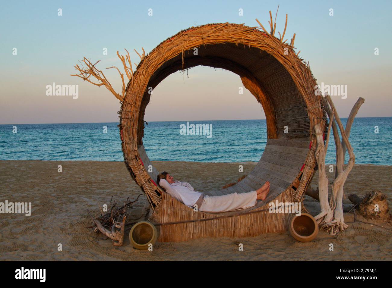 Une touriste féminine se détend dans un transat de Fancy de l'hôtel Regency Sealine Camp à Khor Al Adaid, Qatar, 04 décembre 2021. © Peter Schatz / Alamy Live News Banque D'Images