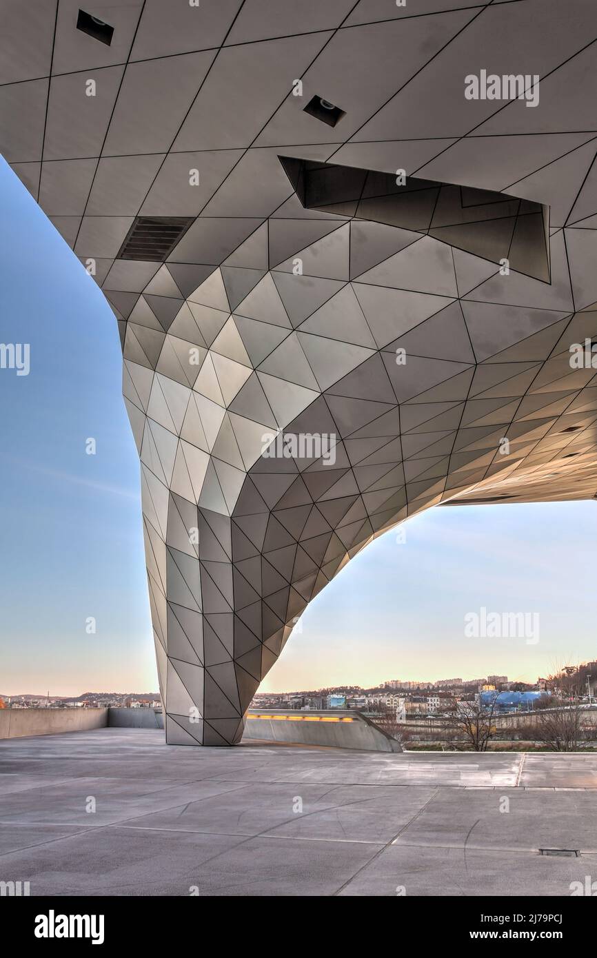 Un pilar à facettes organiques, l'une des caractéristiques les plus proéminentes du Musée des Confluences à Lyon, en France, la nuit. Le bâtiment en déconstructiviste Banque D'Images