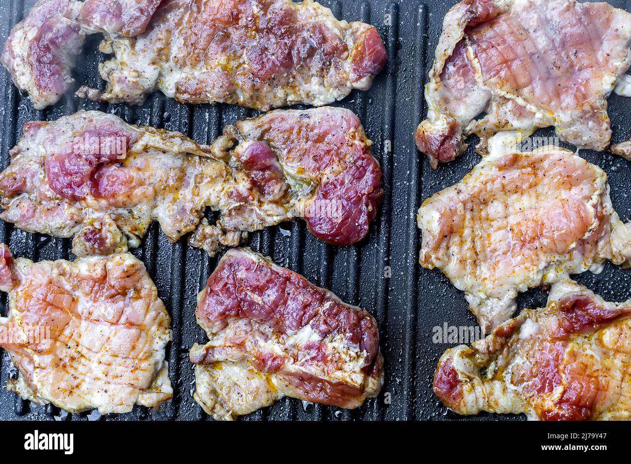 Steaks de porc juteux sur le barbecue en téflon Banque D'Images
