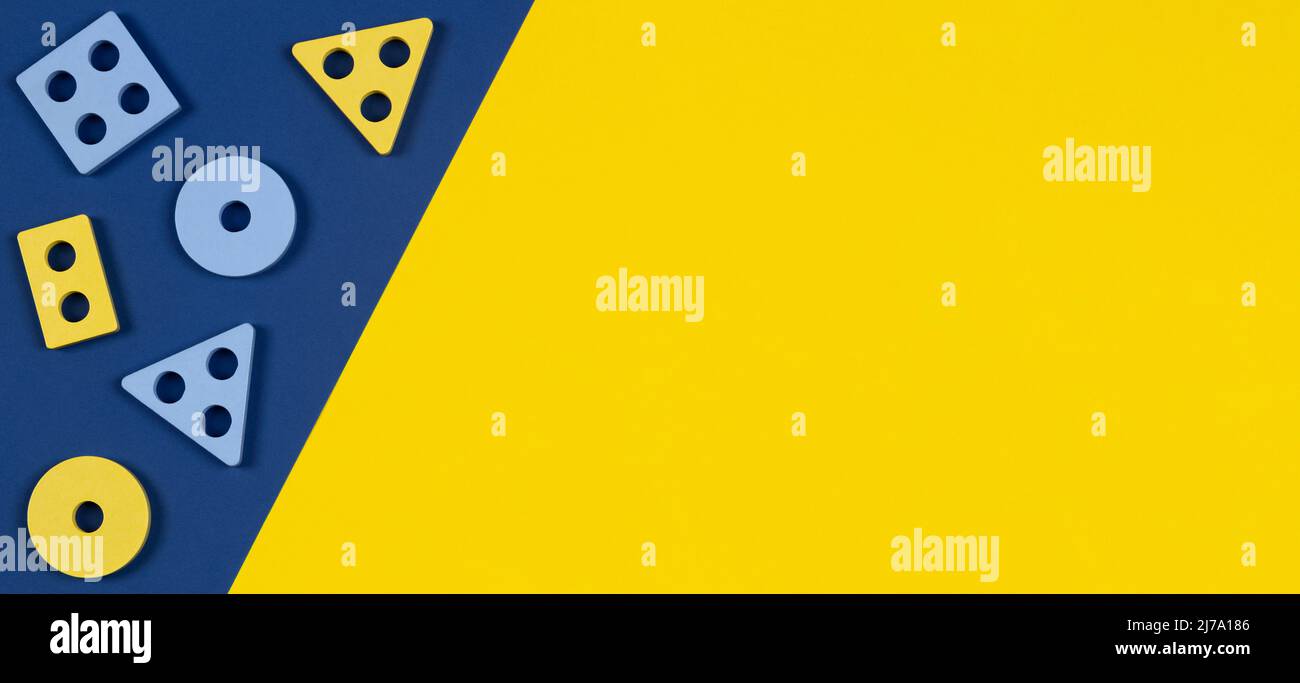 Vue de dessus sur les blocs de bois de la forme trieur pièces jouet sur fond jaune et bleu de couleur. Jouets éducatifs en bois Montessori pour enfants. Petite enfance Banque D'Images