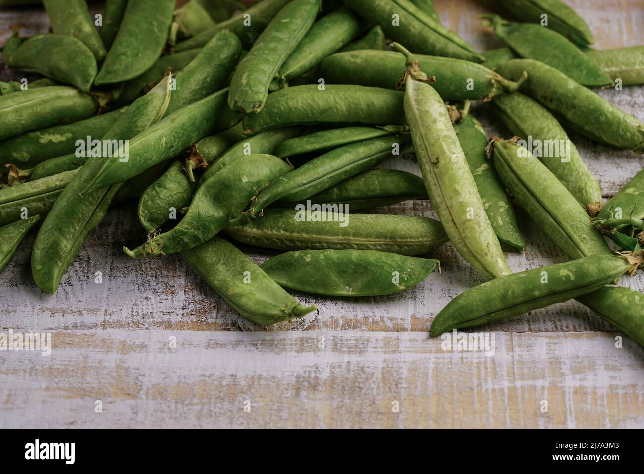 pile de petits pois frais sur une table en bois Banque D'Images