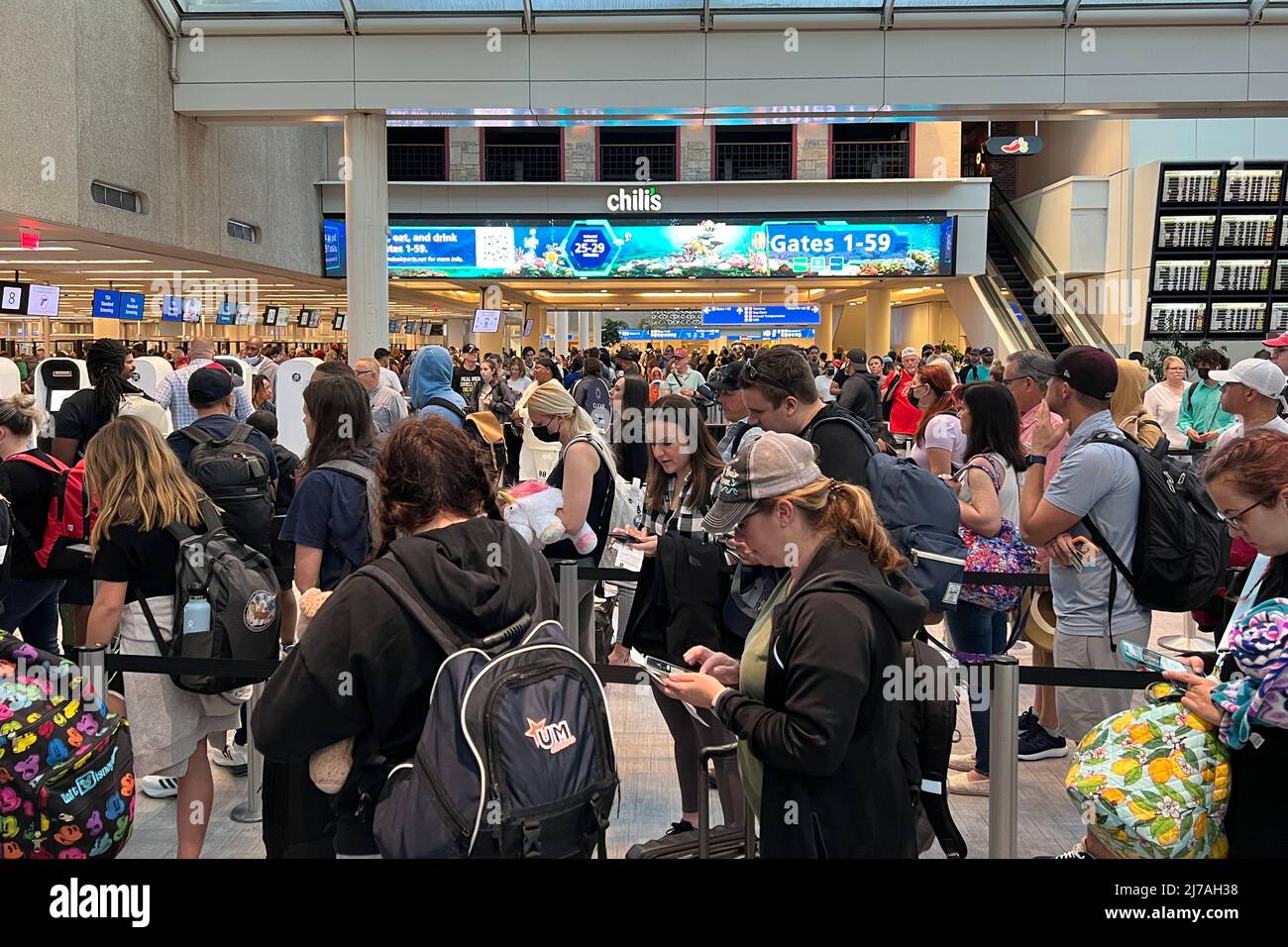 Les passagers se tiennent dans une ligne de contrôle de la TSA à l'aéroport international d'Orlando, le mardi 3 mai 2022, à Orlando, Fla. Banque D'Images