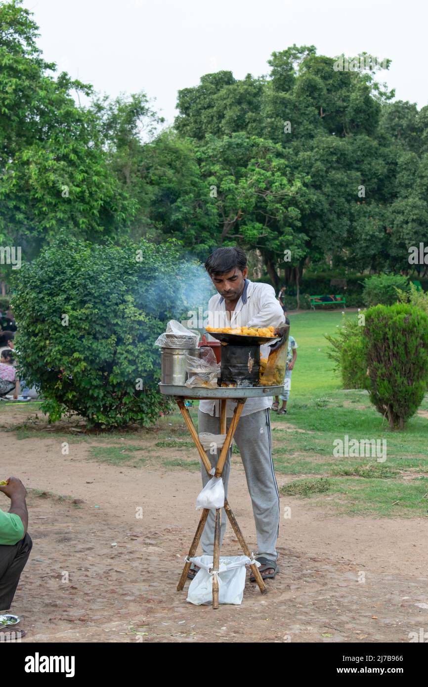 Gardien indien balayant un chemin de jardin avec un balai traditionnel tout en entretenant un parc public verdoyant en plein air en Inde Banque D'Images