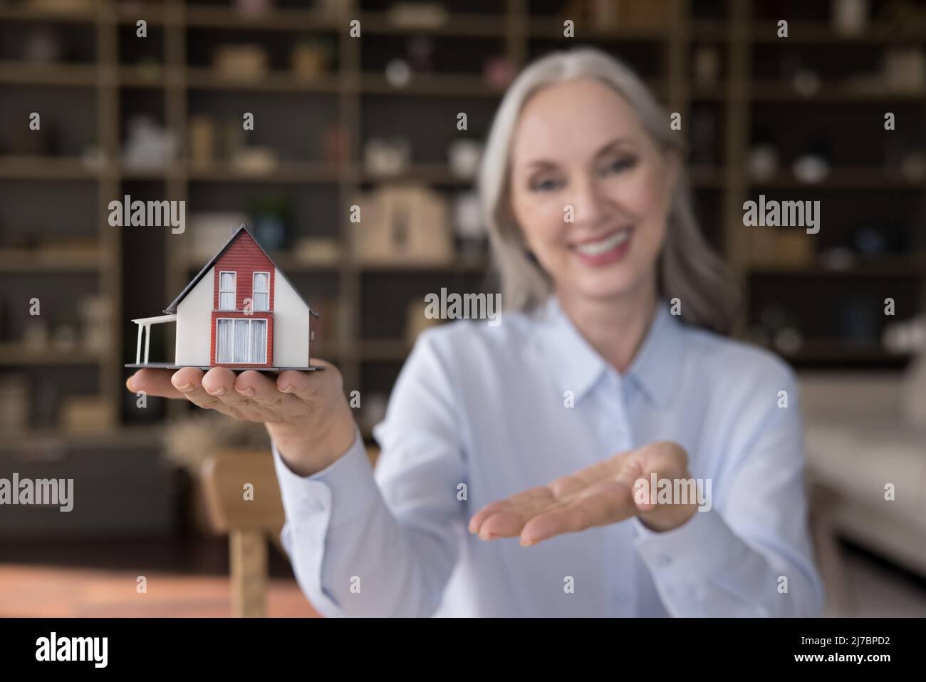 Happy senior agent, femme de realtor, vendeur montrant la petite maison Banque D'Images