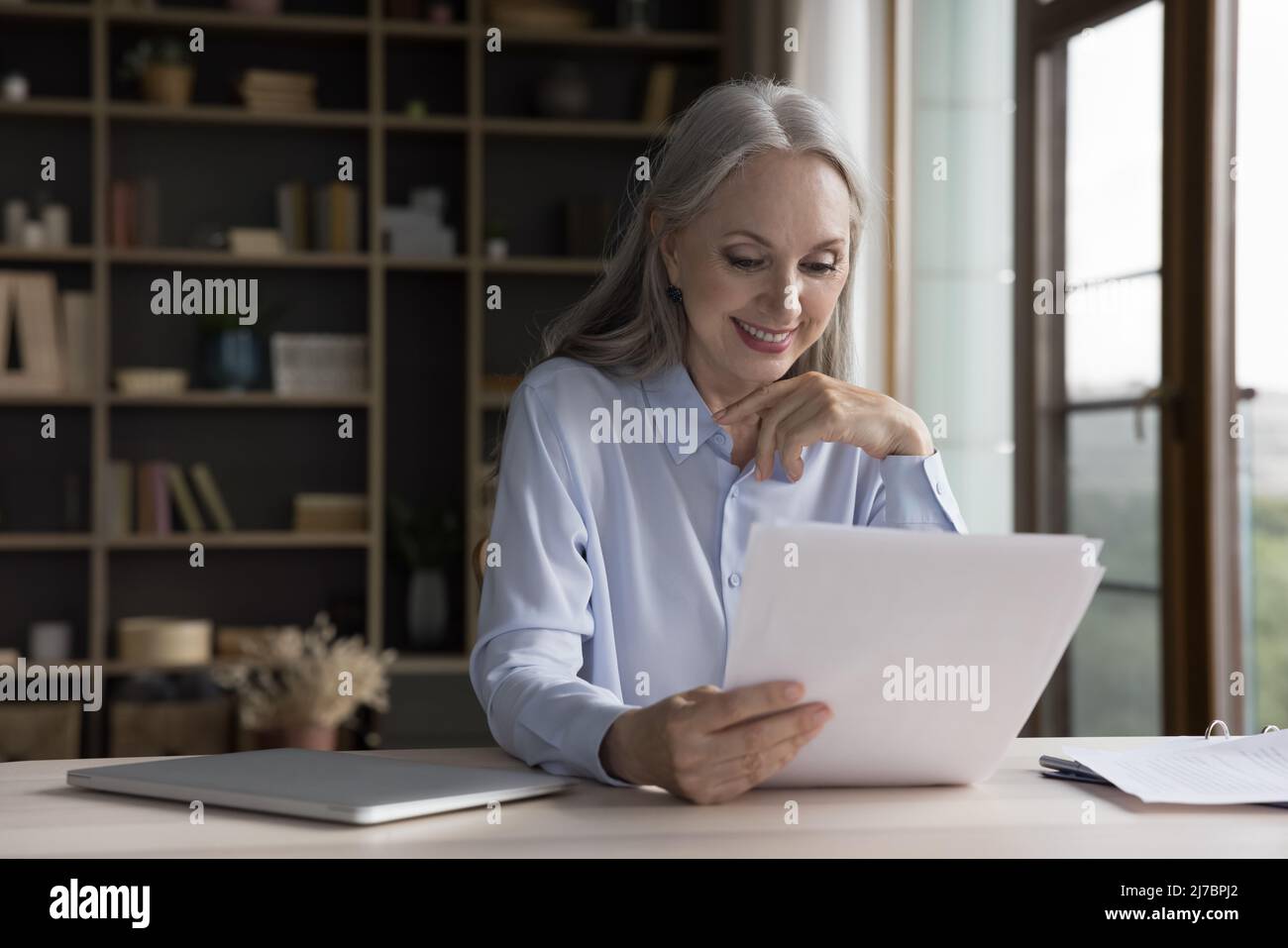 Bonne femme d'affaires freelance lisant papier lettre avec de bonnes nouvelles Banque D'Images
