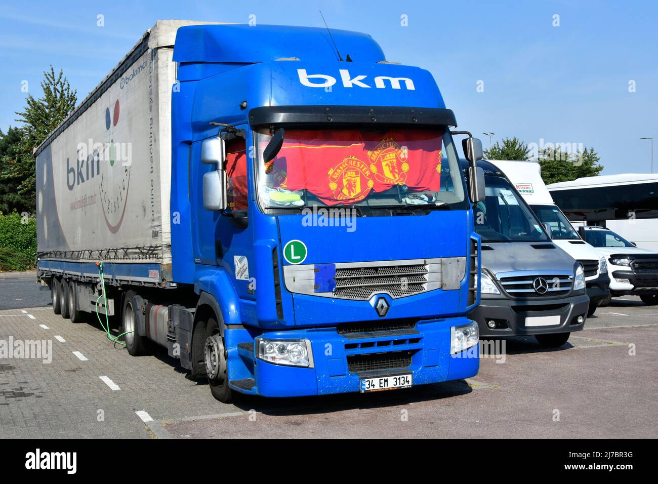 BKM Turque bleu Renault hgv camion et remorque garés pour sommeil break UK autoroute services rouge Manchester United Supporters rideau dans la fenêtre de la cabine Banque D'Images