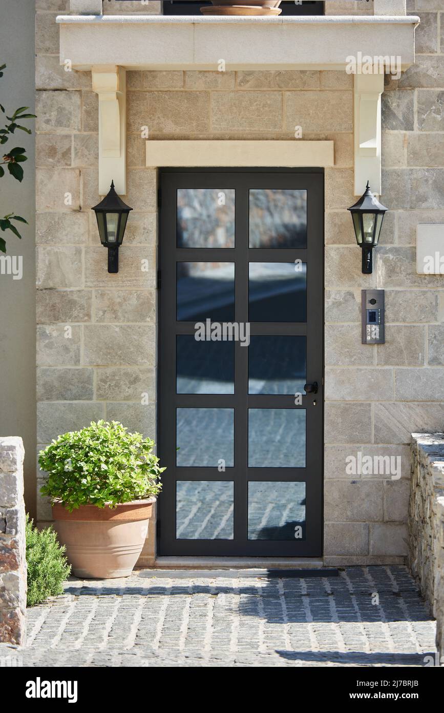 Façade moderne avec mur en pierre et porte en verre Banque D'Images