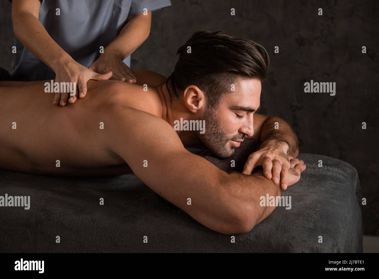 Massage du dos sur le corps de l'homme dans le salon de spa. Concept de soins de beauté. Banque D'Images