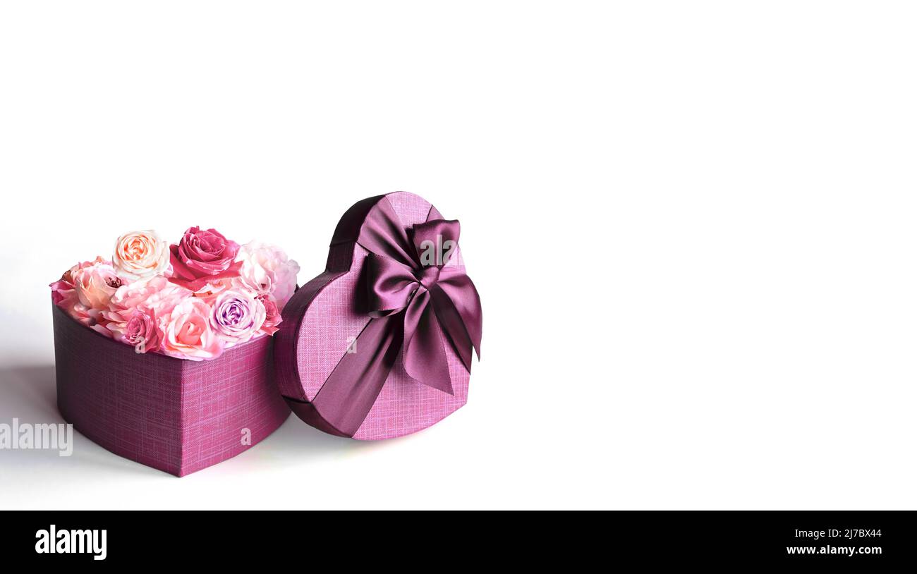 Boîte cadeau et bouquet en forme de coeur. Fleurs un cadeau en forme de coeur. Roses dans une boîte coeur sur fond blanc Banque D'Images